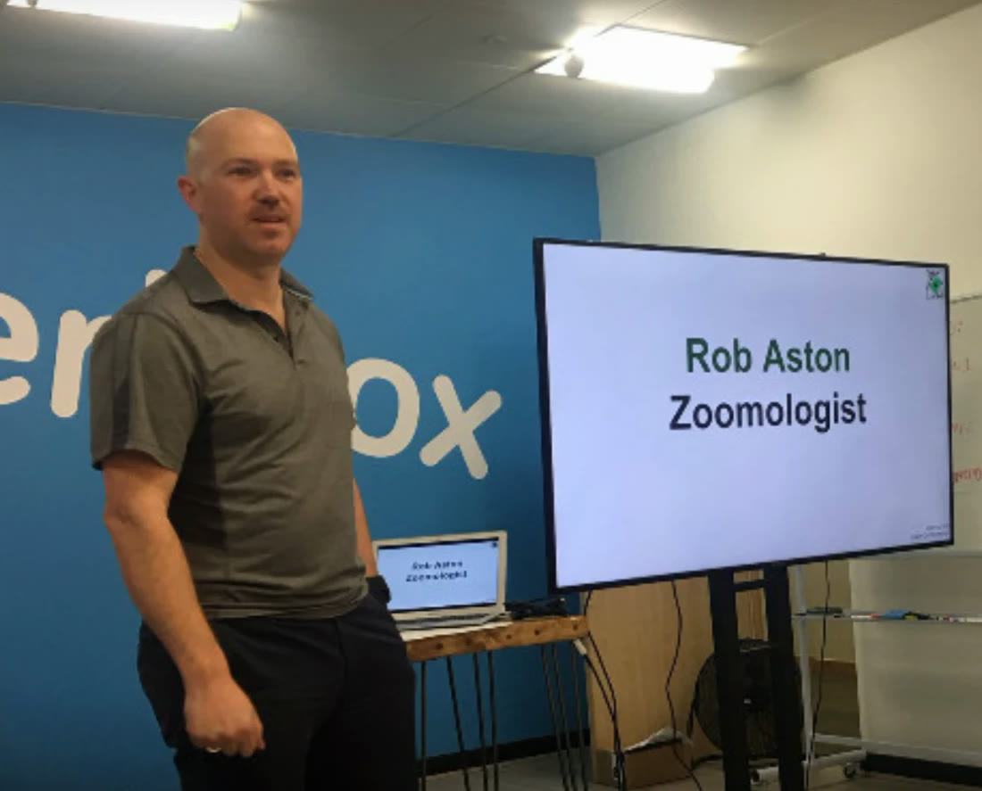 Rob Aston presenting at a Zoom-Out workshop, standing beside a screen that reads “Rob Aston, Zoomologist”