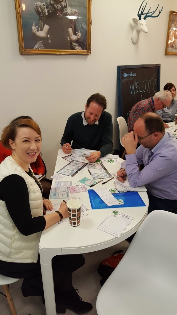Participants working through Zoom-Out cards and worksheets around a table